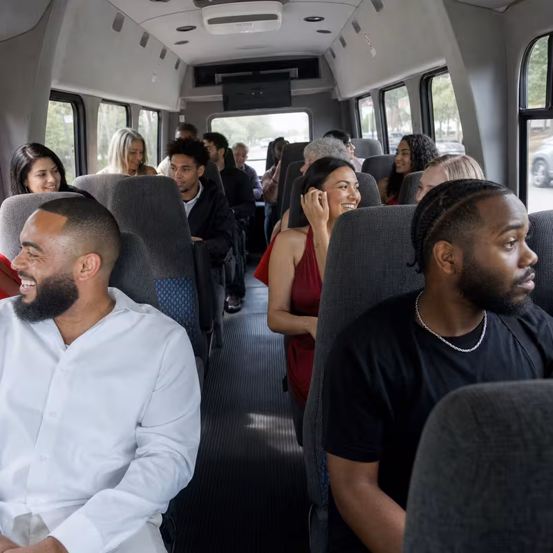 Group boarding a white charter bus for Private Event Transportation transportation in Orlando